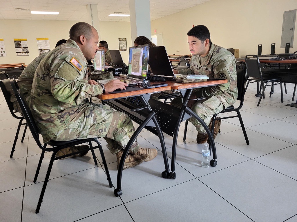 Soldiers in Class C uniforms, seated at computers