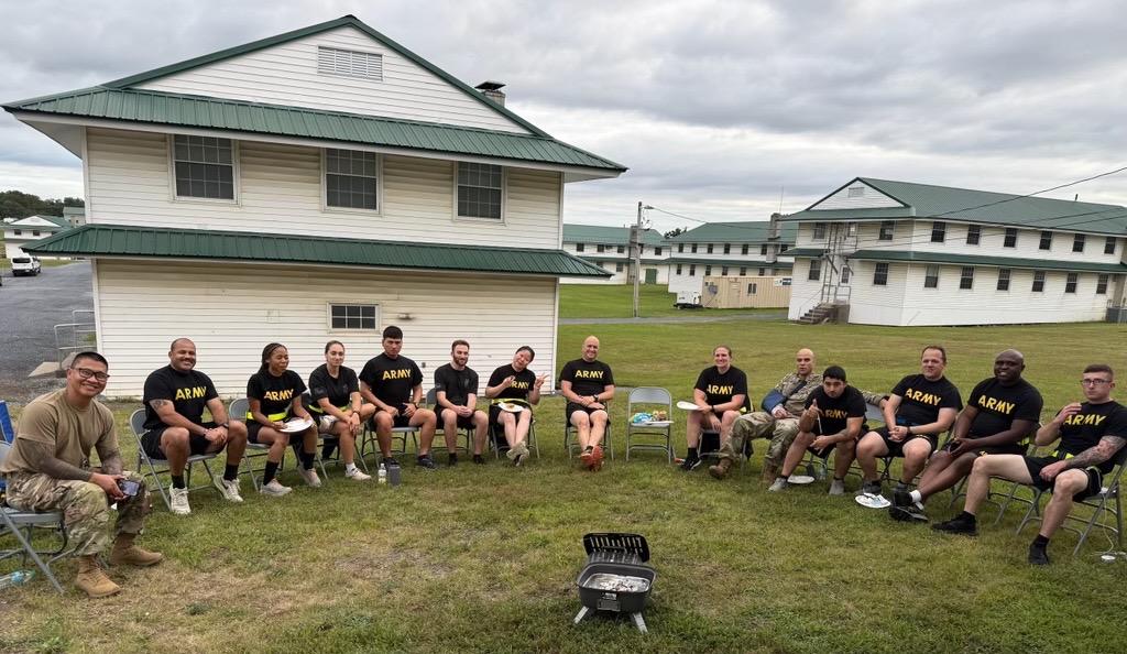Soldiers in Class C Uniform and Army Physical Fitness Uniforms (APFU), seated