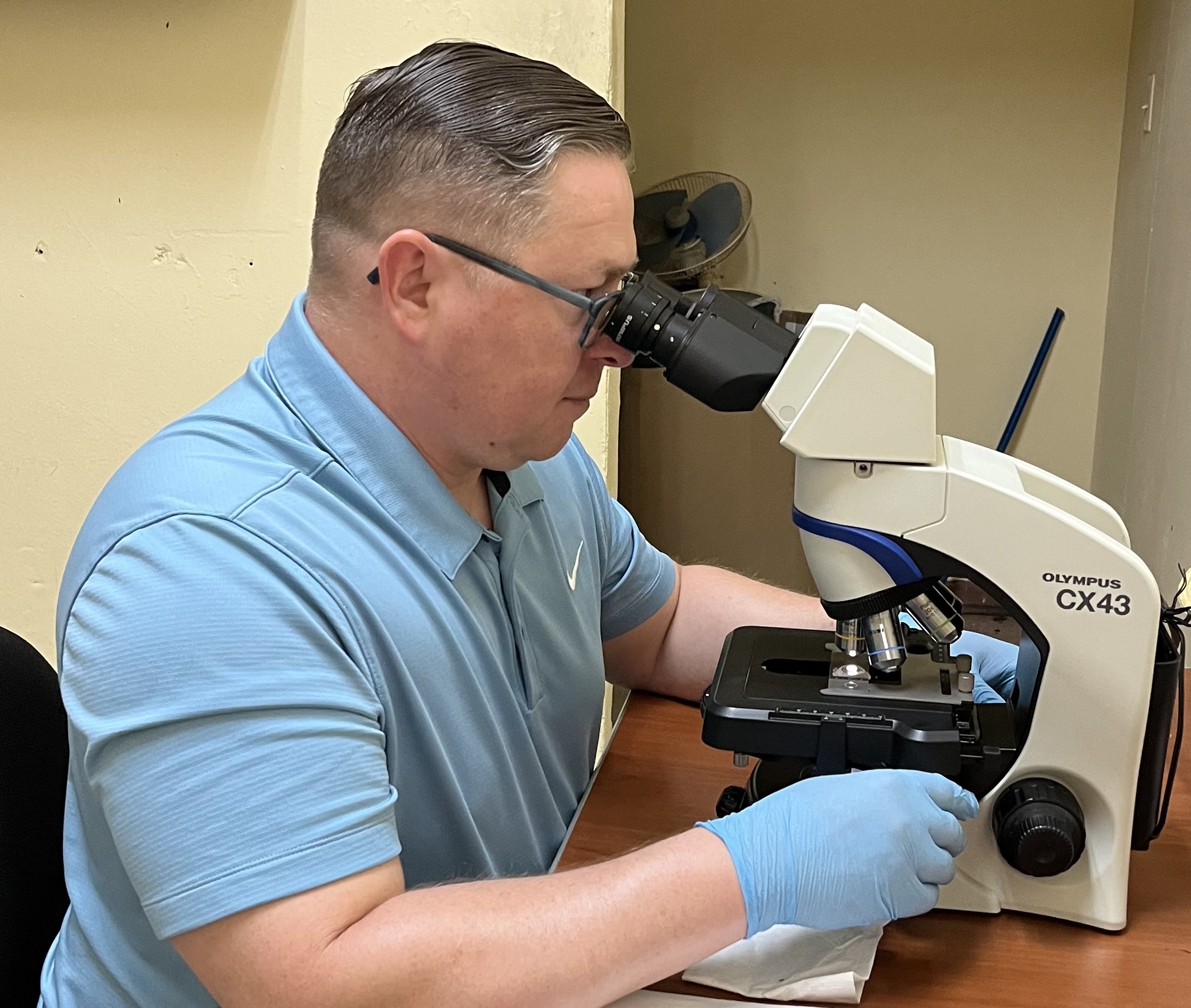Photo of man examining specimen using microscope